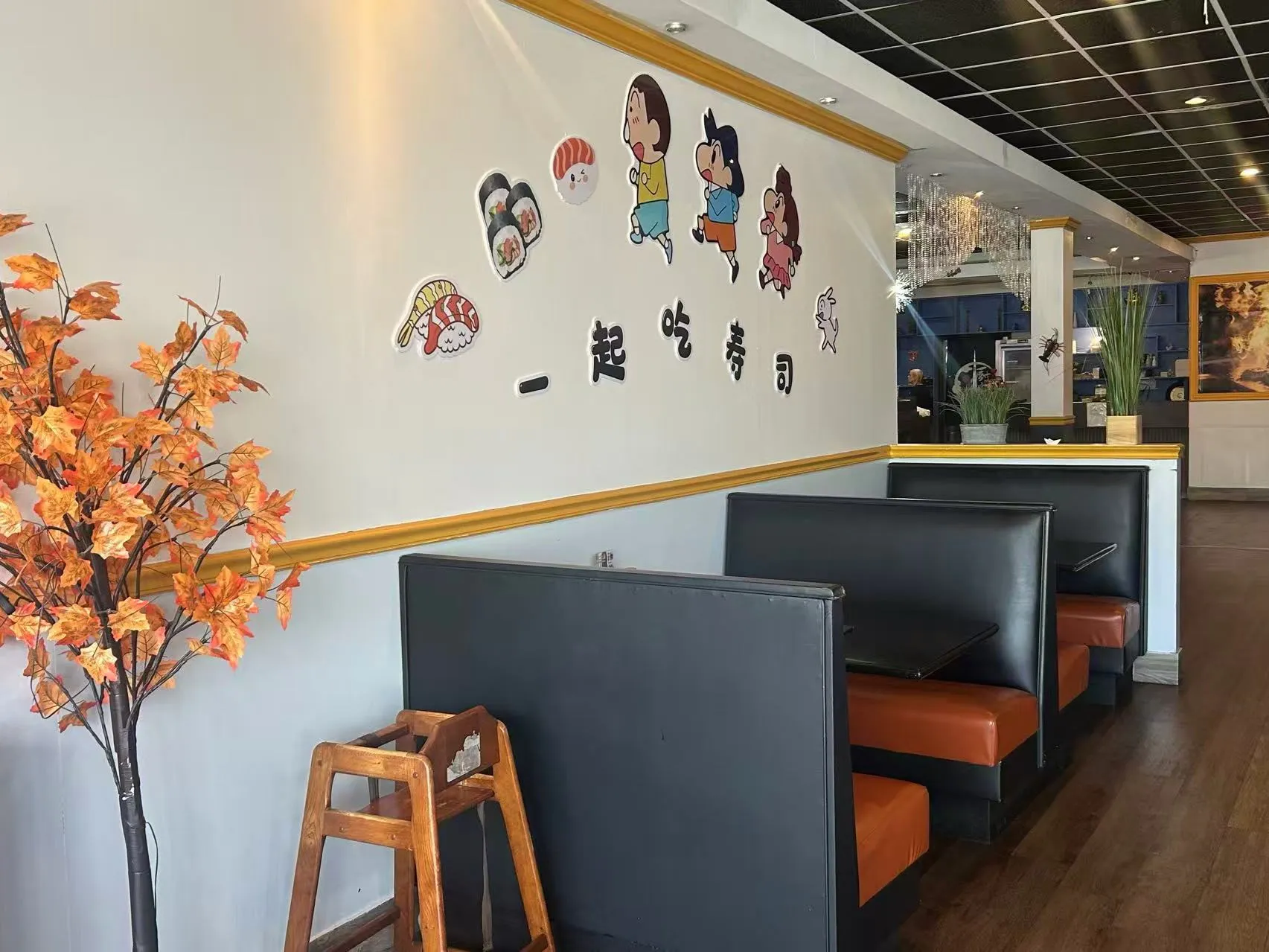 Cozy restaurant dining area with cartoon wall decals and booth seating at Sakura Sushi Restaurant, a Japanese Restaurant in Live Oak