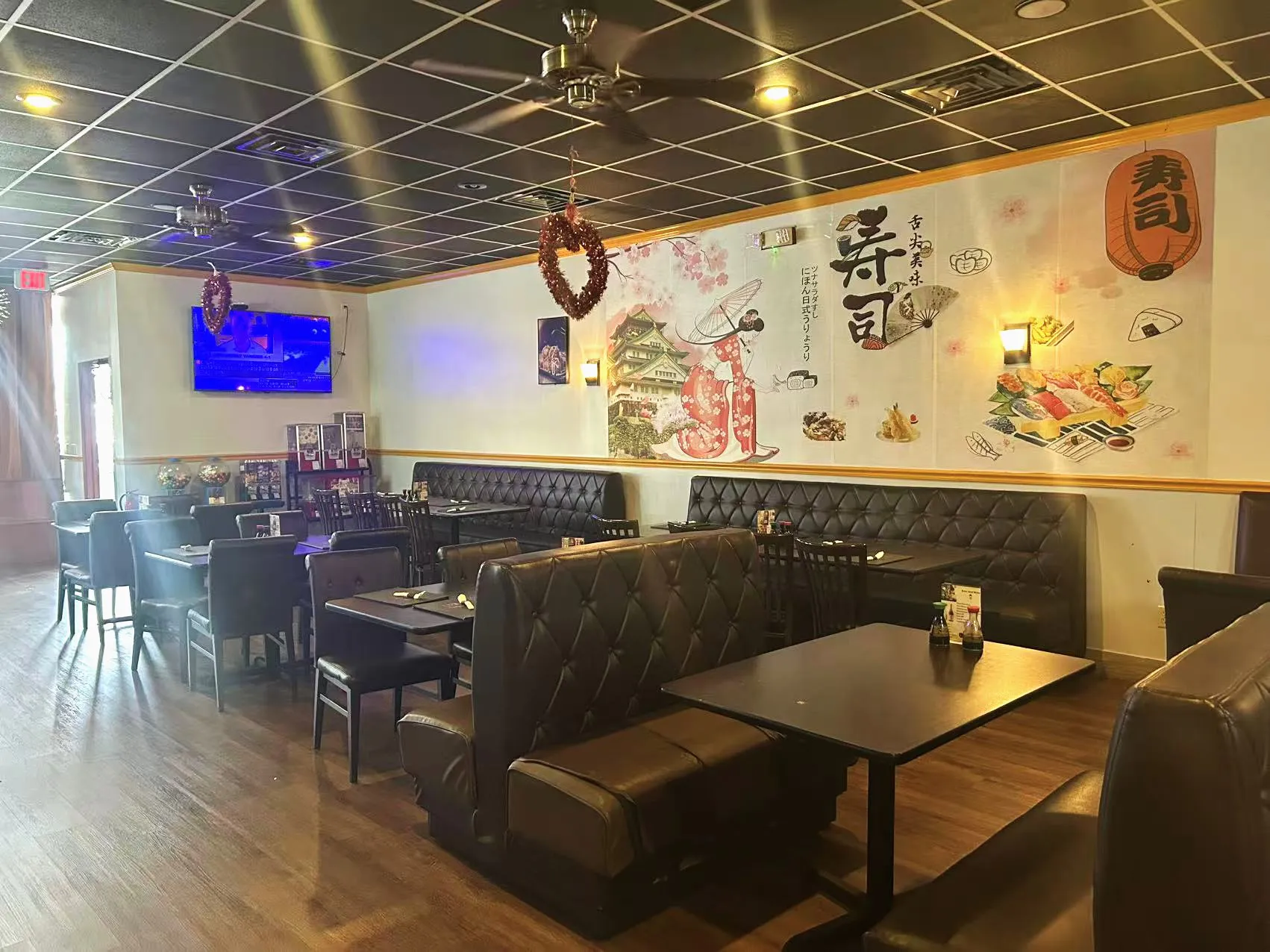 Spacious restaurant interior with leather booths, wall murals and dining tables at Sakura Sushi Restaurant, a Japanese Restaurant in Live Oak